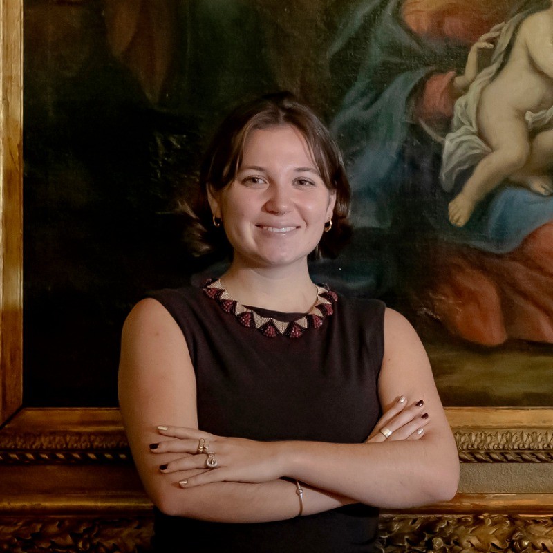 Jessica Redington standing in front of a classical oil painting